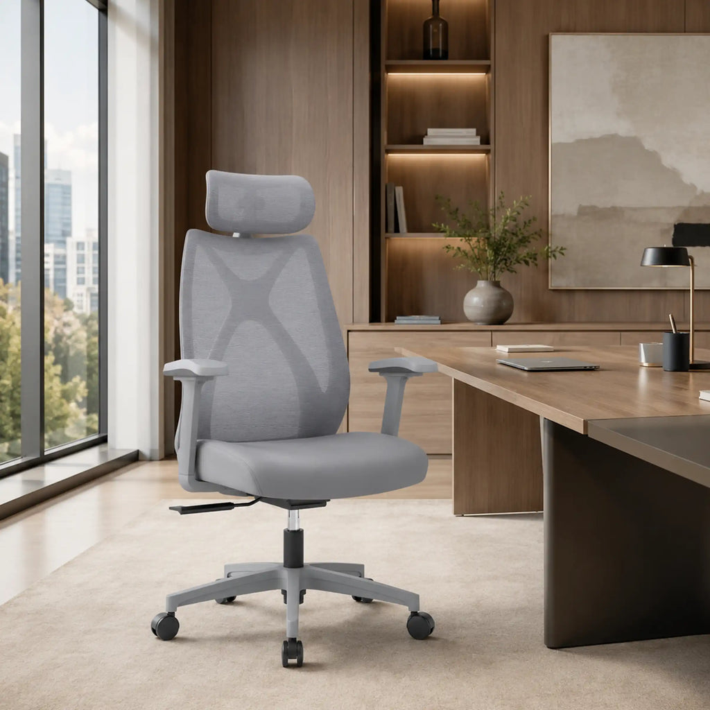 Angled view of grey Prime Ergonomic Chair with cushioned fabric seat, mesh headrest and supportive PVC armrests.