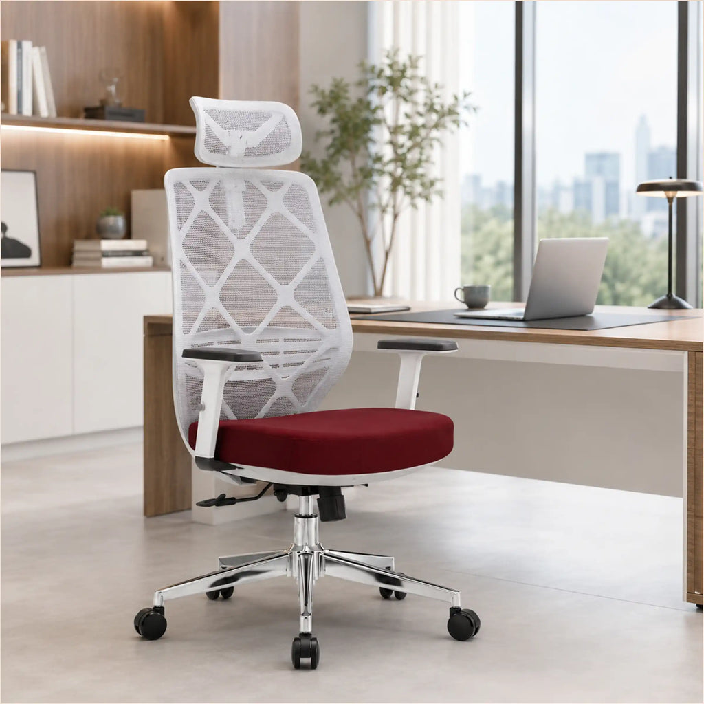 A modern mesh office chair with a white geometric backrest, red cushioned seat, and chrome five-star base, positioned in front of a wooden desk in a bright, contemporary home office.